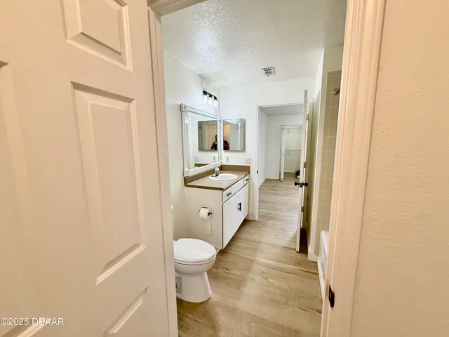 a large white bathroom with toilet sink and mirror