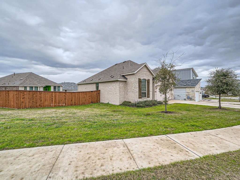 11400 American Mustang Loop Manor, TX 78653 - Photo 2 of 24 a view of a big house with a big yard and large tree