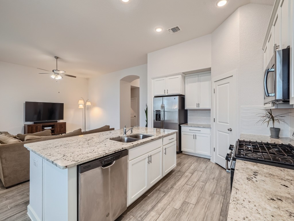 11400 American Mustang Loop Manor, TX 78653 - Photo 4 of 24 a kitchen with a stove a sink and a refrigerator