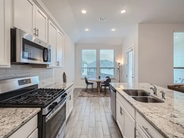 a kitchen with stainless steel appliances granite countertop a stove and a sink