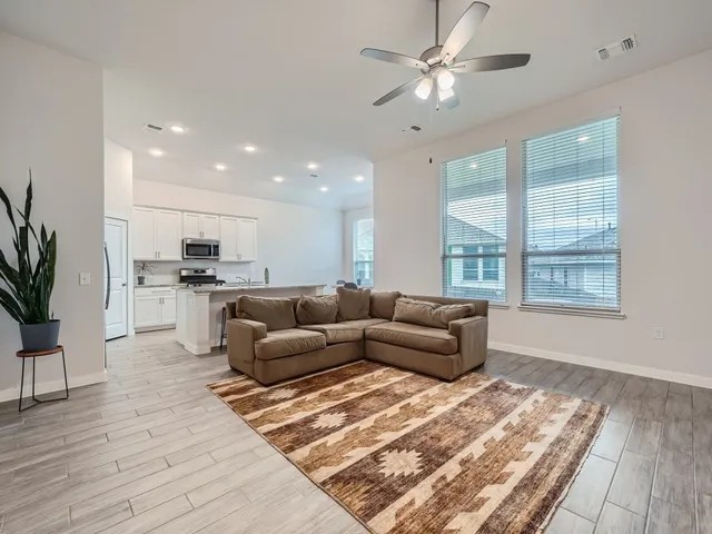 a living room with furniture and kitchen view