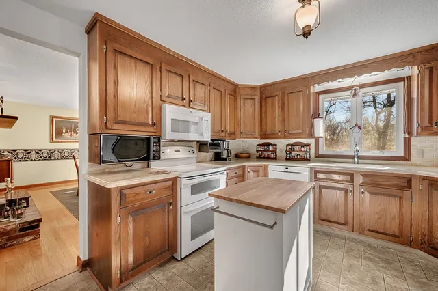 a kitchen with cabinets appliances and a window