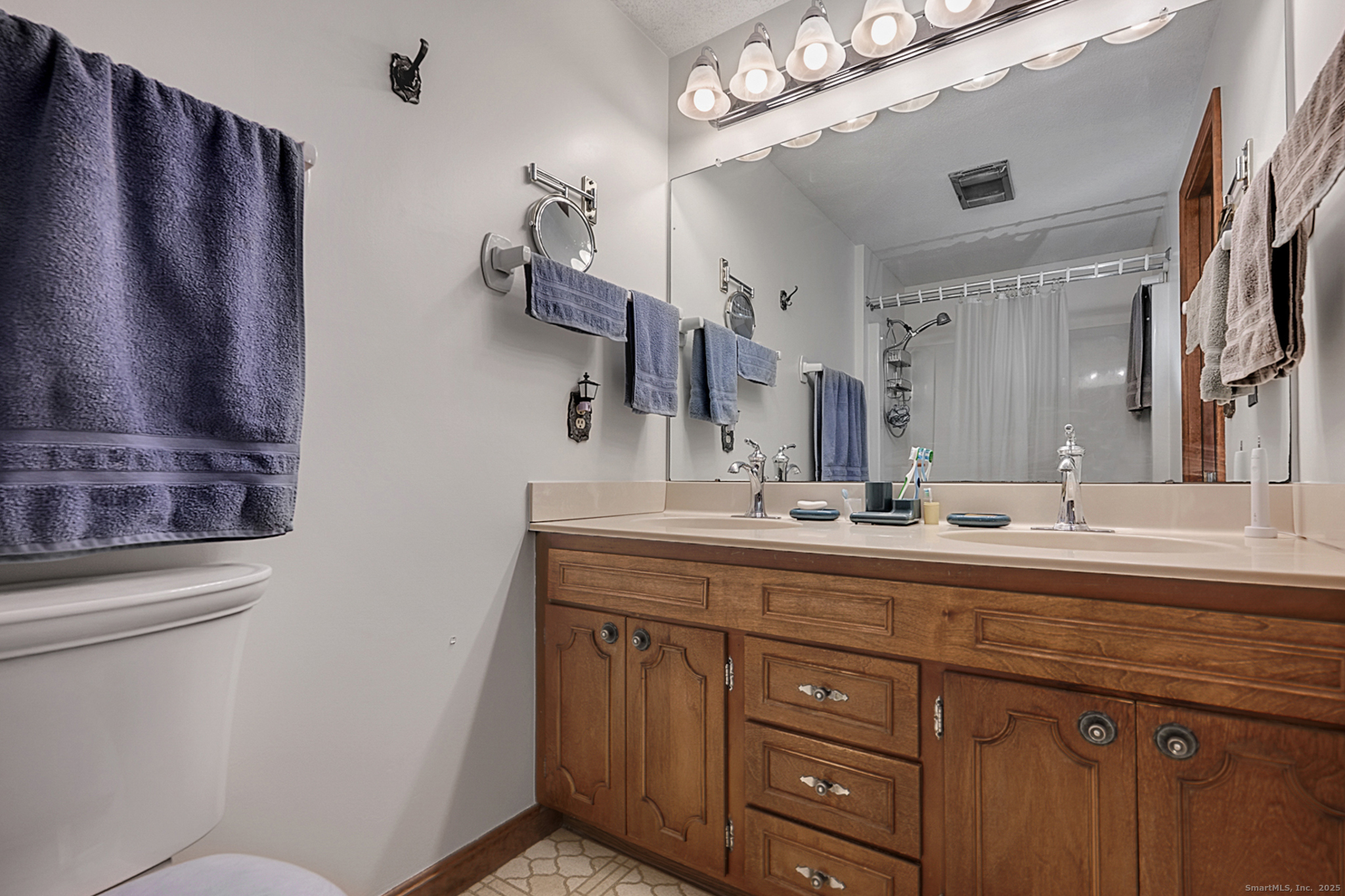 52 Wood Creek Road Burlington, CT 06013 - Photo 20 of 40 a bathroom with a granite countertop sink a toilet and a mirror