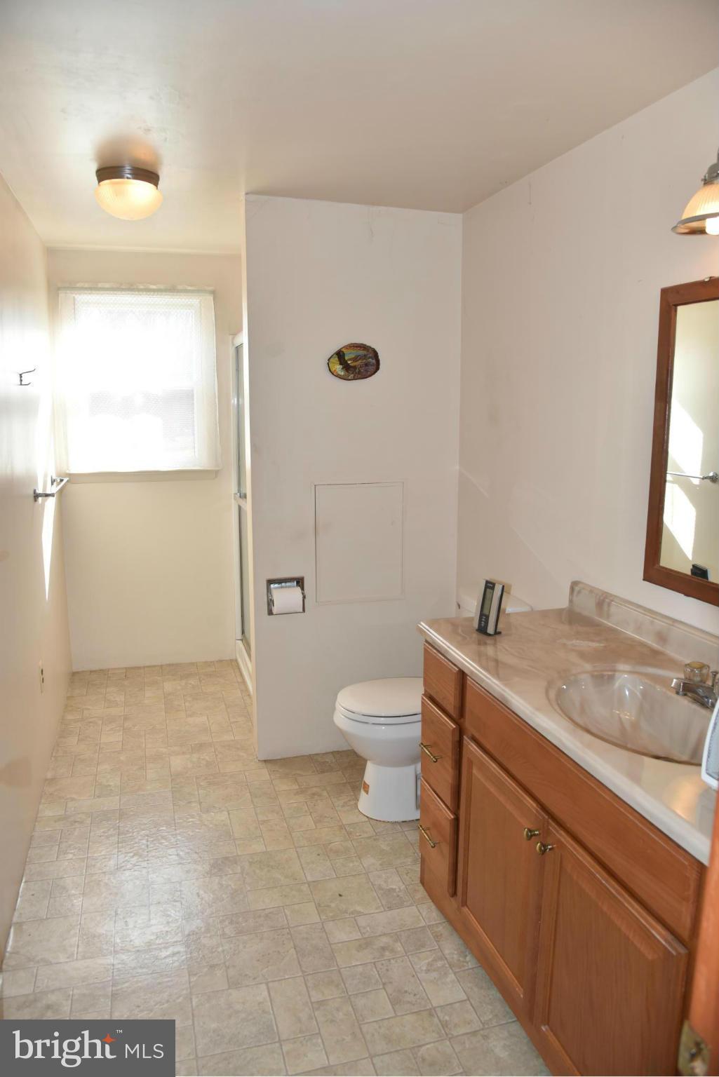 3905 Salem Bottom Road Westminster, MD 21157 - Photo 18 of 26 a bathroom with a granite countertop sink a toilet and a mirror