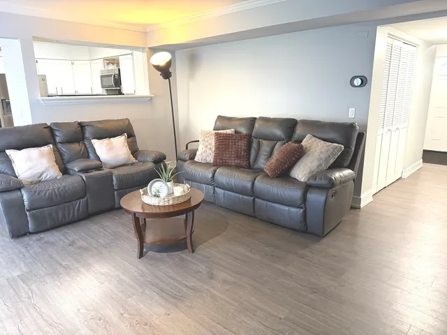a living room with furniture a wooden floor and a window