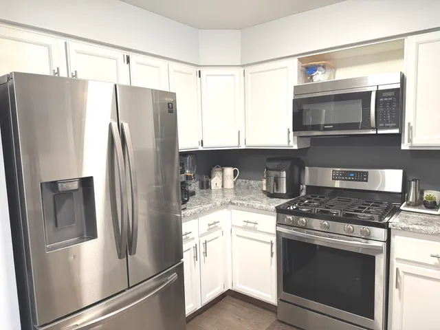 a kitchen with stainless steel appliances a refrigerator stove and microwave