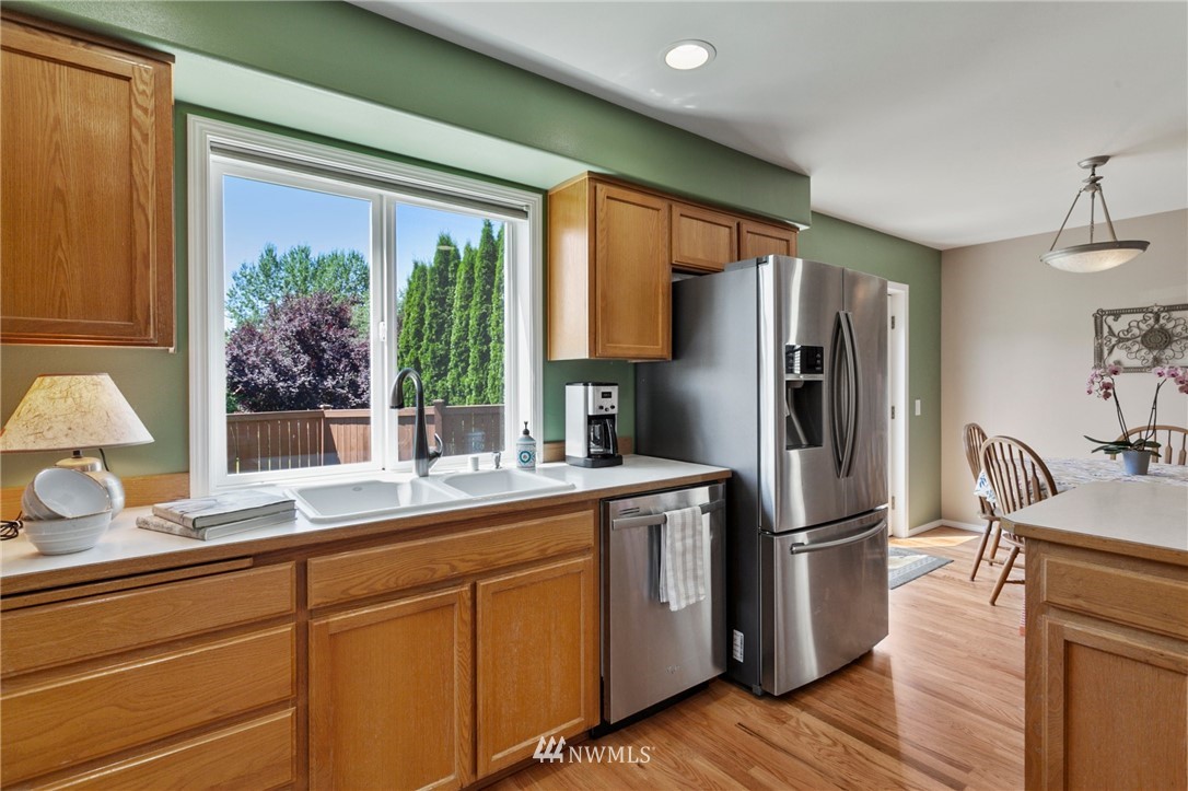 913 232nd Street Southwest Bothell, WA 98021 - Photo 6 of 34 a kitchen with stainless steel appliances a refrigerator a sink and wooden floors