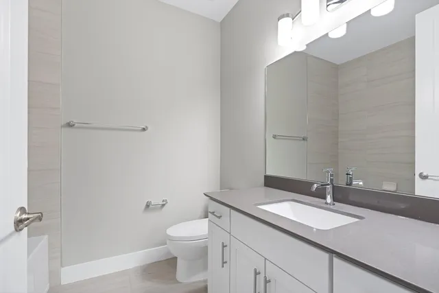 a bathroom with a granite countertop sink a toilet and a mirror