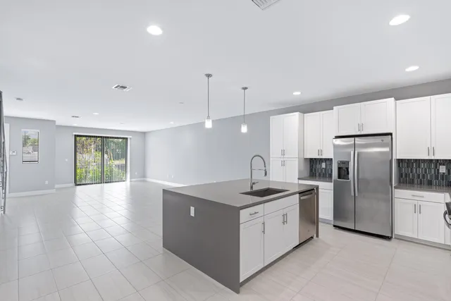 a kitchen with stainless steel appliances granite countertop a sink a refrigerator and a stove
