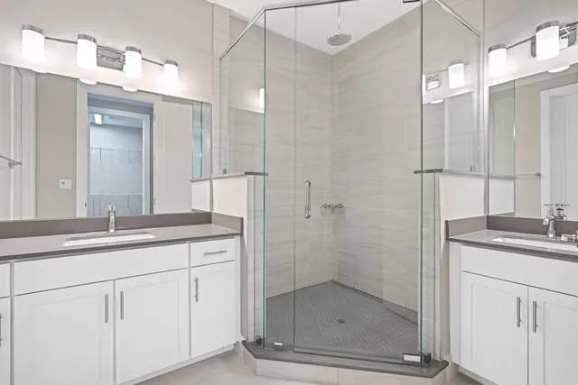 a bathroom with a shower sink and mirror