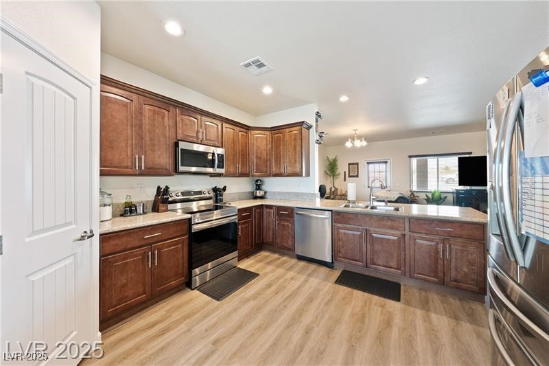 760 Fort Churchill Road Pahrump, NV 89060 - Photo 7 of 33 Kitchen featuring a chandelier, appliances with stainless steel finishes, recessed lighting, a peninsula, and light wood finished floors