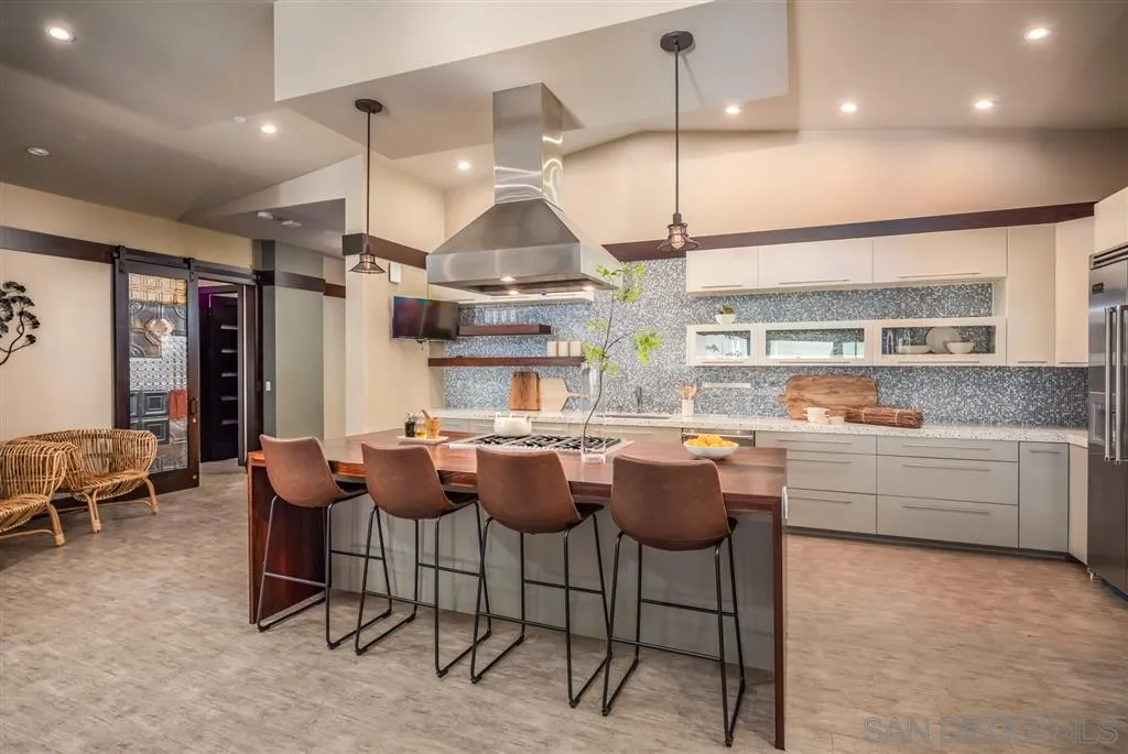 5630 Soledad Road La Jolla, CA 92037 - Photo 11 of 25 a kitchen with stainless steel appliances granite countertop a sink a stove and a wooden floors