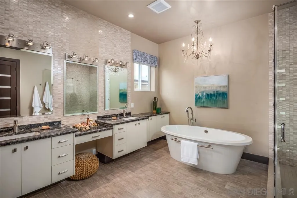 5630 Soledad Road La Jolla, CA 92037 - Photo 14 of 25 a bathroom with a double vanity sink a toilet a mirror and shower