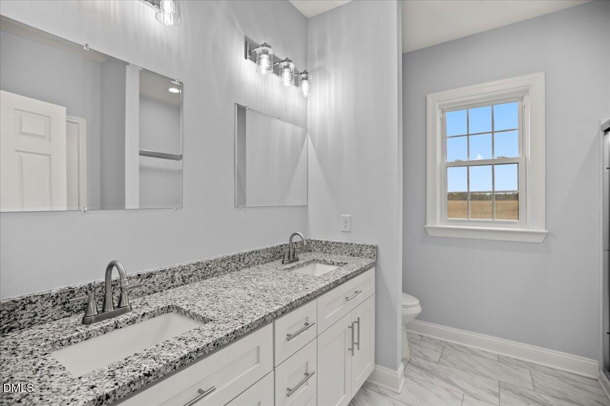 1300 Nick Coley Road Whitakers, NC 27891 - Photo 38 of 47 a bathroom with a granite countertop sink and a mirror