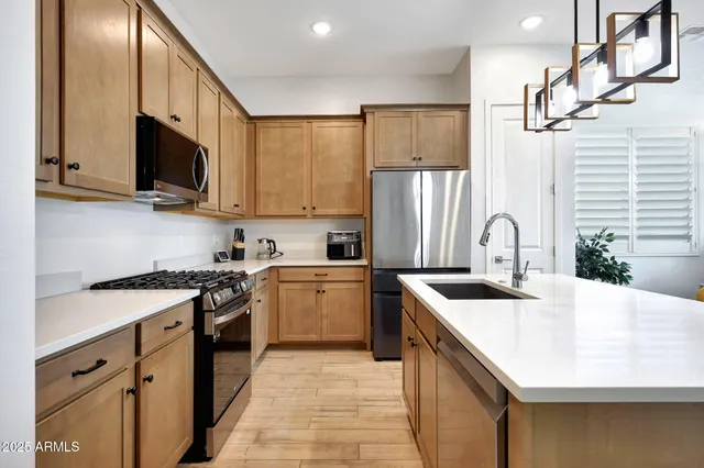 a kitchen with stainless steel appliances granite countertop a sink stove and refrigerator