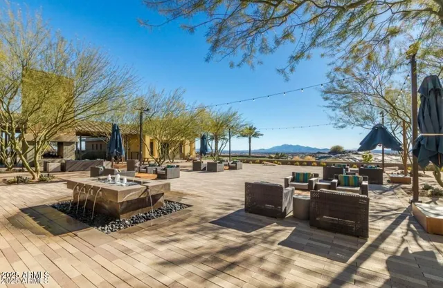 a view of a patio with couches table and chairs under an umbrella