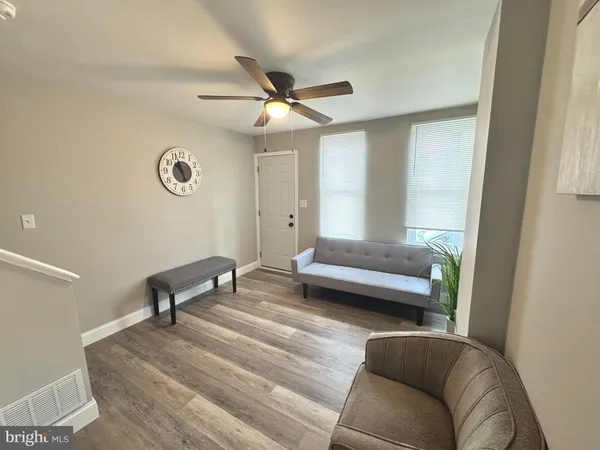a living room with furniture and a wooden floor