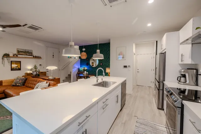 a large white kitchen with sink and washing machine