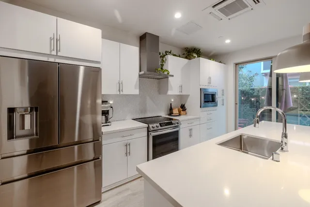 a kitchen with white cabinets and stainless steel appliances