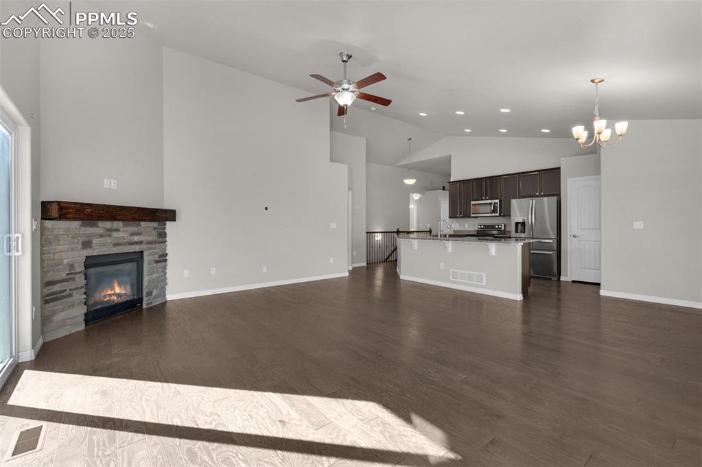 6131 Anders Ridge Lane Colorado Springs, CO 80927 - Photo 5 of 38 Living area with cozy fireplace, ceiling fan, high vaulted ceiling, and wood finished floors