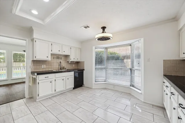 a kitchen with granite countertop a sink cabinets and stainless steel appliances
