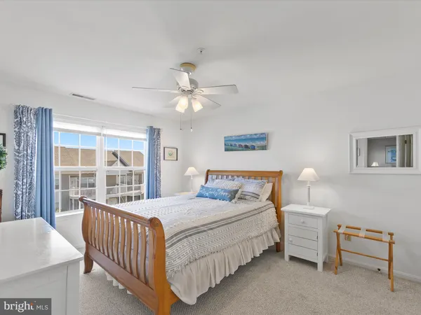 a bedroom with a large bed a chandelier and dresser