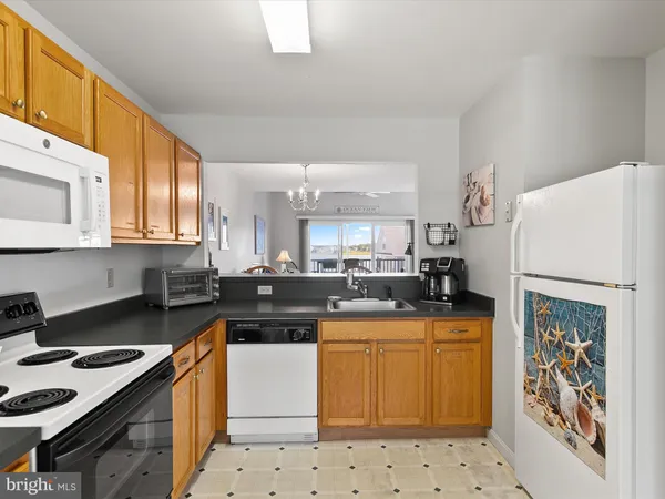 a kitchen with stainless steel appliances a stove a sink a table and chairs