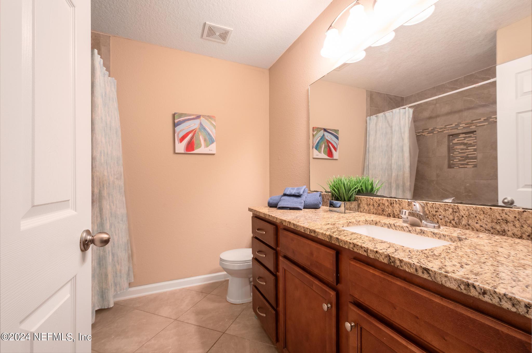 9890 Fraser Road Jacksonville, FL 32246 - Photo 15 of 23 a bathroom with a granite countertop sink mirror vanity and toilet