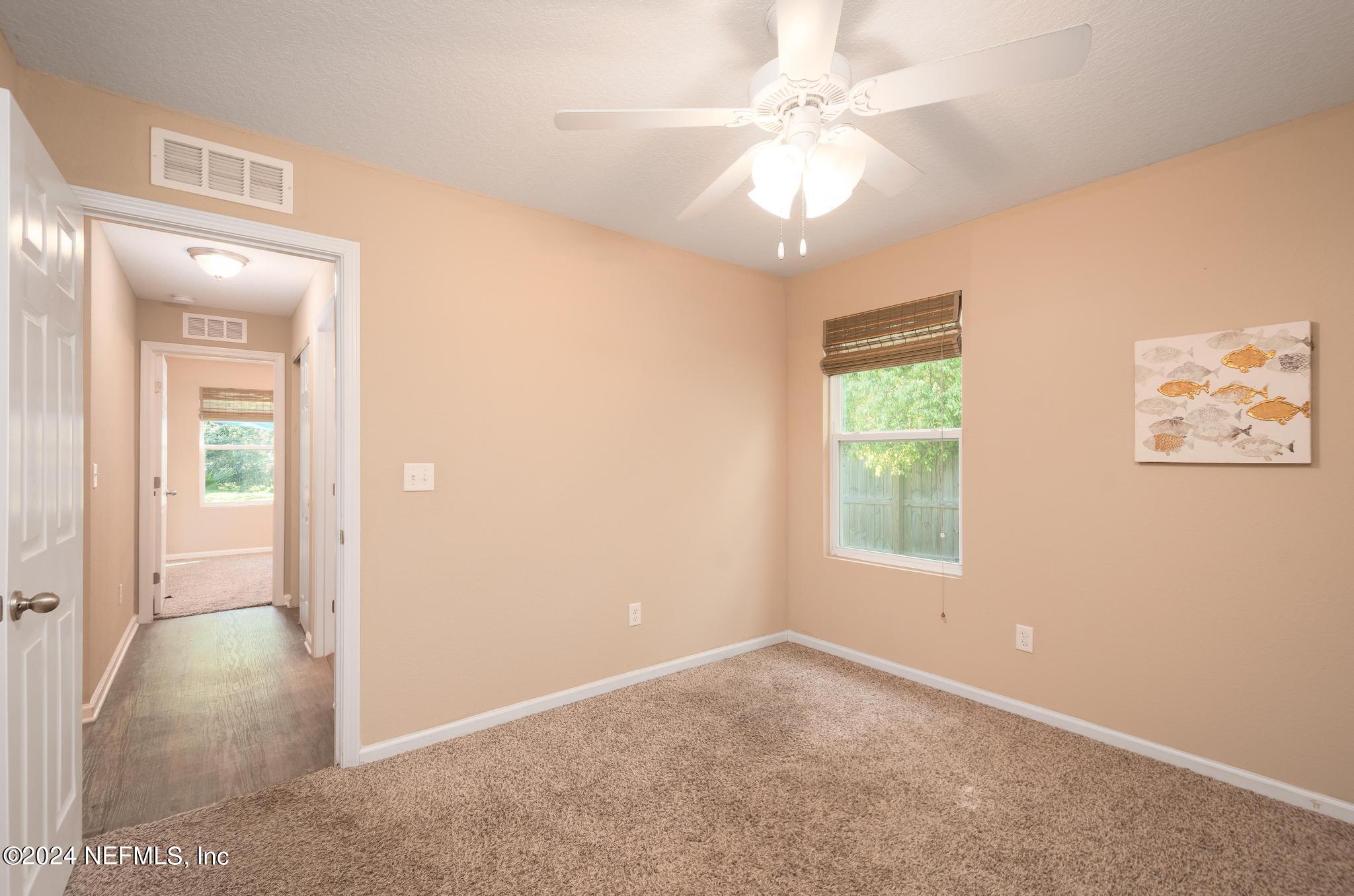 9890 Fraser Road Jacksonville, FL 32246 - Photo 16 of 23 an empty room with windows and ceiling fan