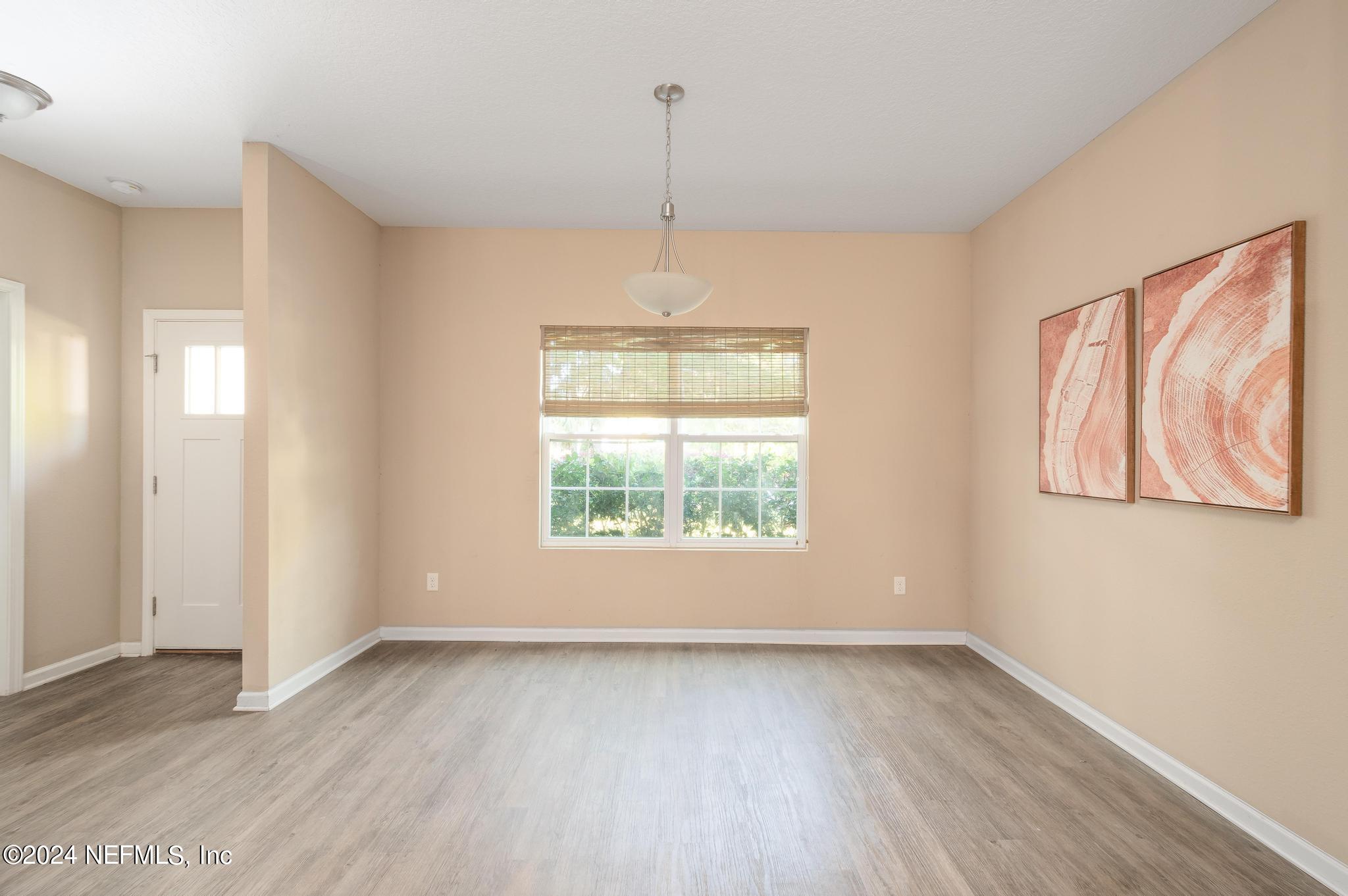9890 Fraser Road Jacksonville, FL 32246 - Photo 3 of 23 an empty room with wooden floor and windows