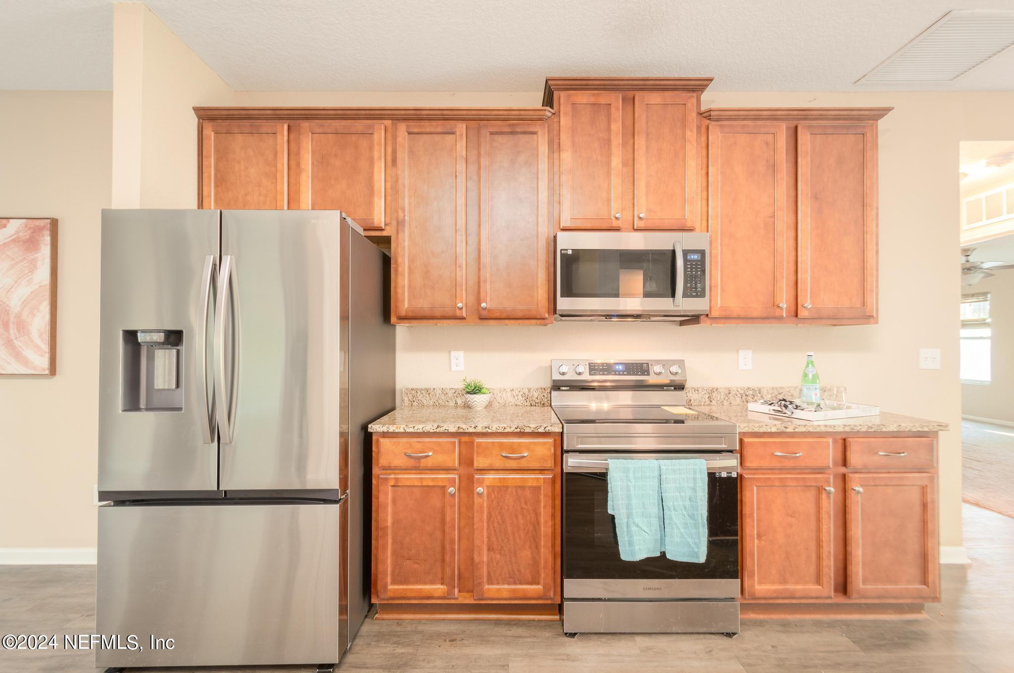 9890 Fraser Road Jacksonville, FL 32246 - Photo 6 of 23 a kitchen with stainless steel appliances granite countertop a refrigerator a stove a sink and a microwave