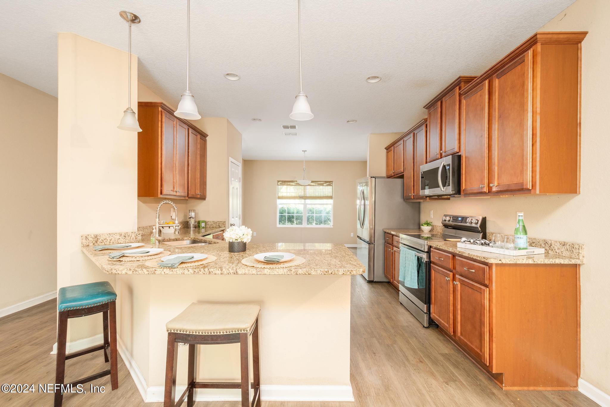 9890 Fraser Road Jacksonville, FL 32246 - Photo 7 of 23 a kitchen with stainless steel appliances granite countertop a sink stove and refrigerator