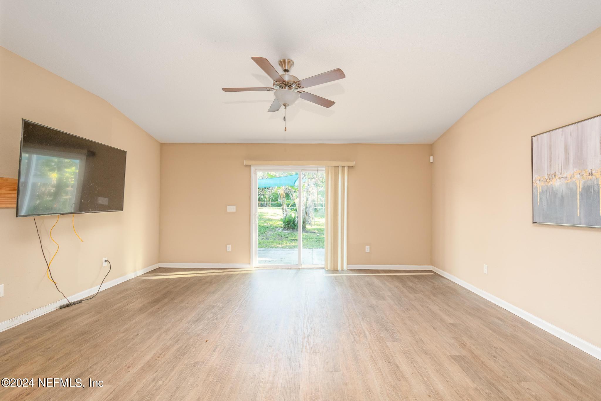 9890 Fraser Road Jacksonville, FL 32246 - Photo 10 of 23 a view of an empty room with wooden floor and a window