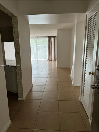 a view of hallway with stairs and a window
