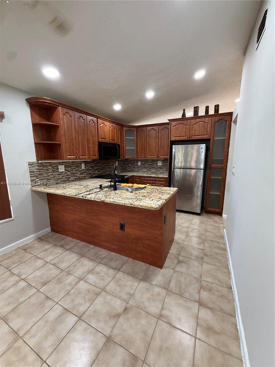 19926 Northwest 67th Place Hialeah, FL 33015 - Photo 2 of 21 a kitchen with stainless steel appliances granite countertop a stove a sink and a refrigerator