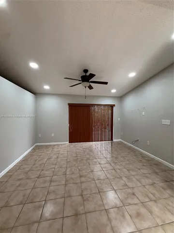 a view of an empty room with a ceiling fan