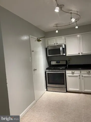a stove top oven sitting inside of a kitchen