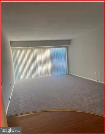 a view of a livingroom with wooden floor and a window