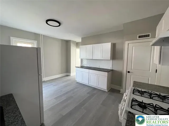 a kitchen with a refrigerator and a stove top oven