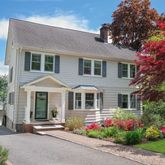 a front view of a house with a yard and trees
