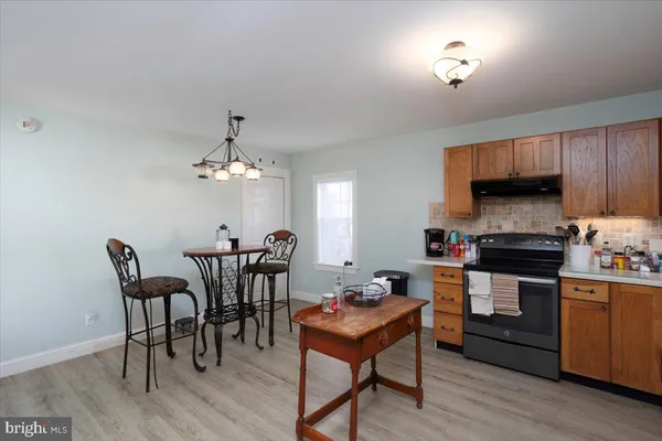 a kitchen with a table chairs microwave and cabinets