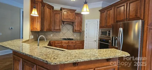 a kitchen with stainless steel appliances granite countertop table and refrigerator
