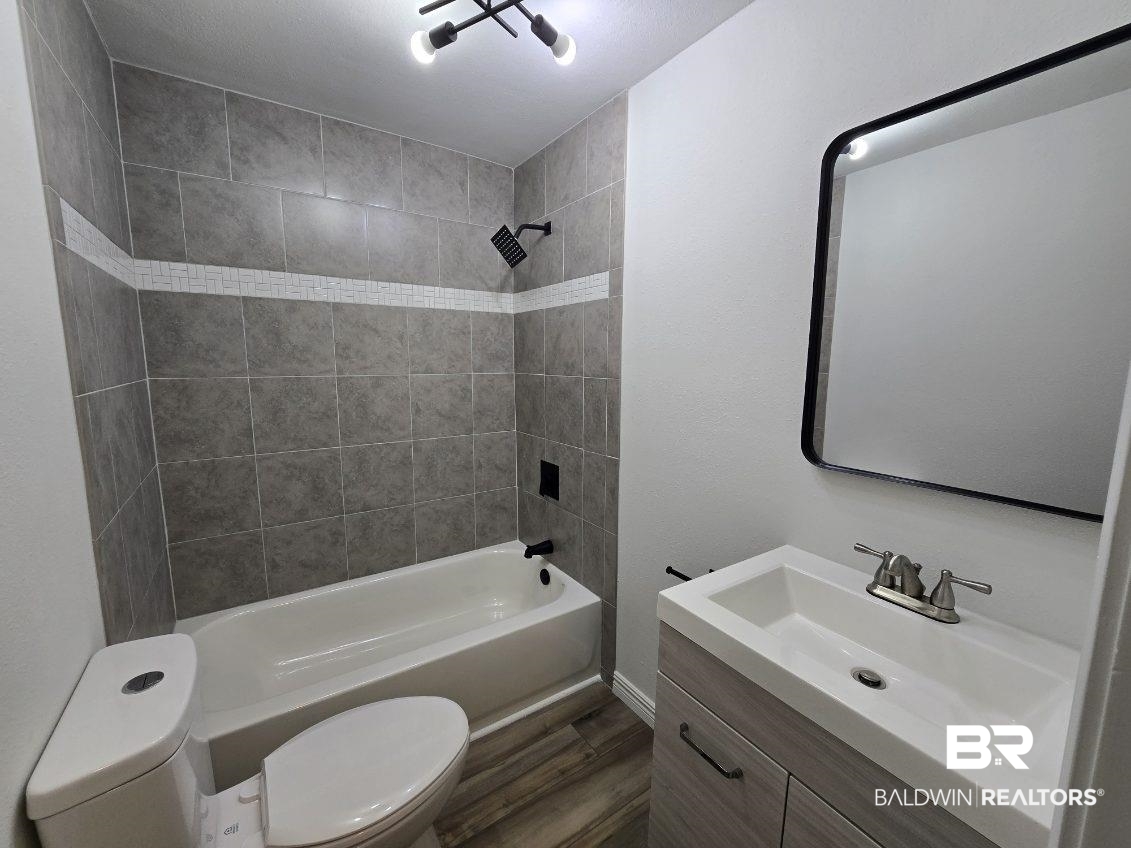 821 Dailey Street Brewton, AL 36426 - Photo 16 of 17 Bathroom with vanity, shower / bathtub combination, and dark wood finished floors