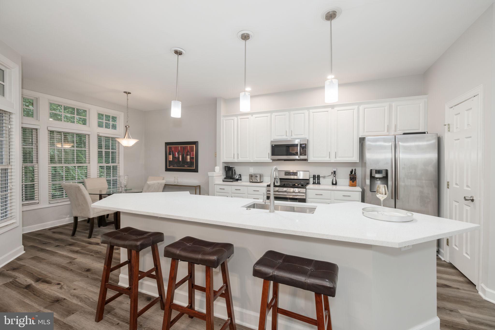 6337 Simmer Circle Springfield, VA 22150 - Photo 11 of 50 a kitchen with stainless steel appliances granite countertop a sink a stove a refrigerator cabinets and chairs