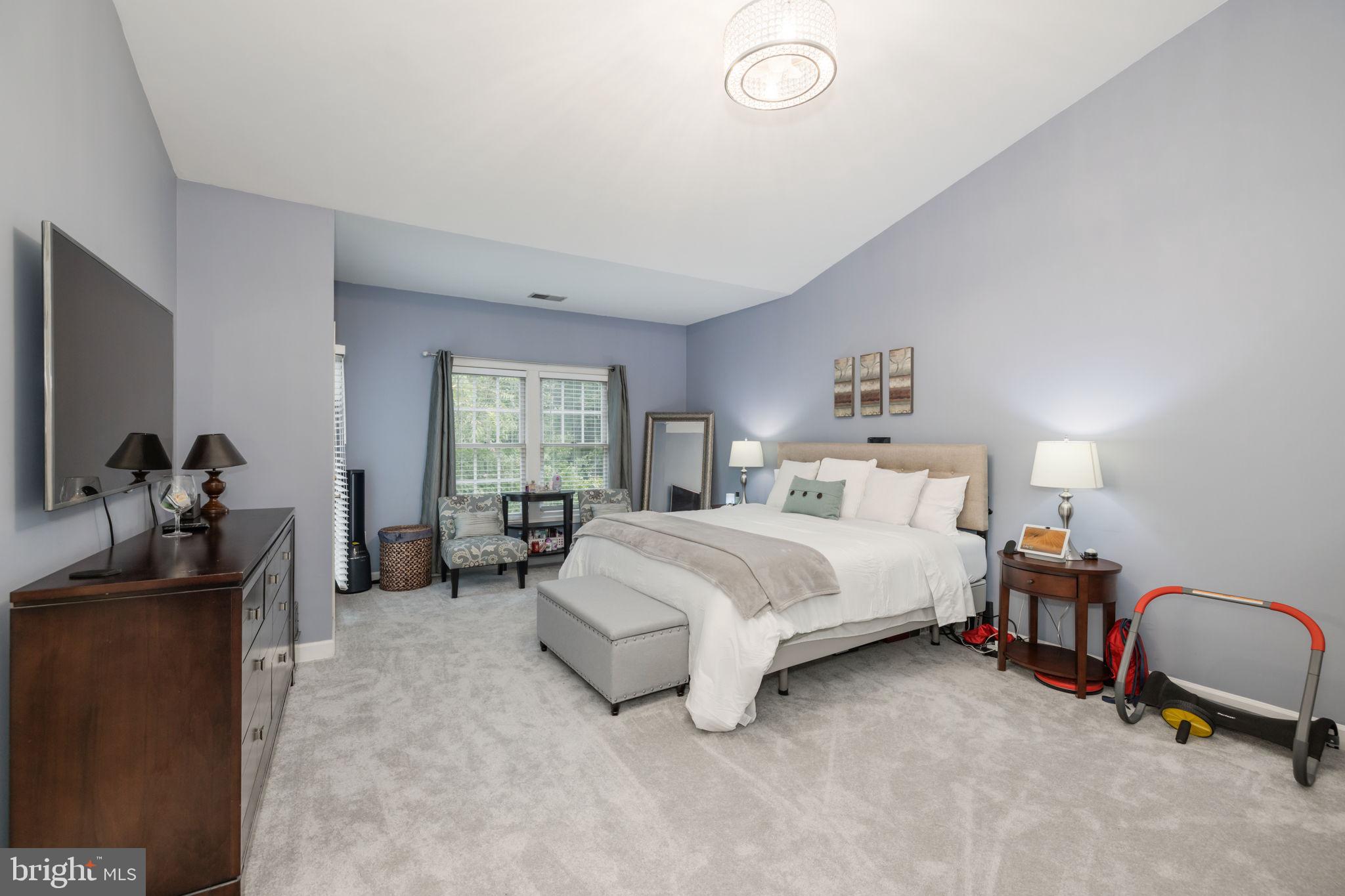 6337 Simmer Circle Springfield, VA 22150 - Photo 32 of 50 a spacious bedroom with a bed and a couch
