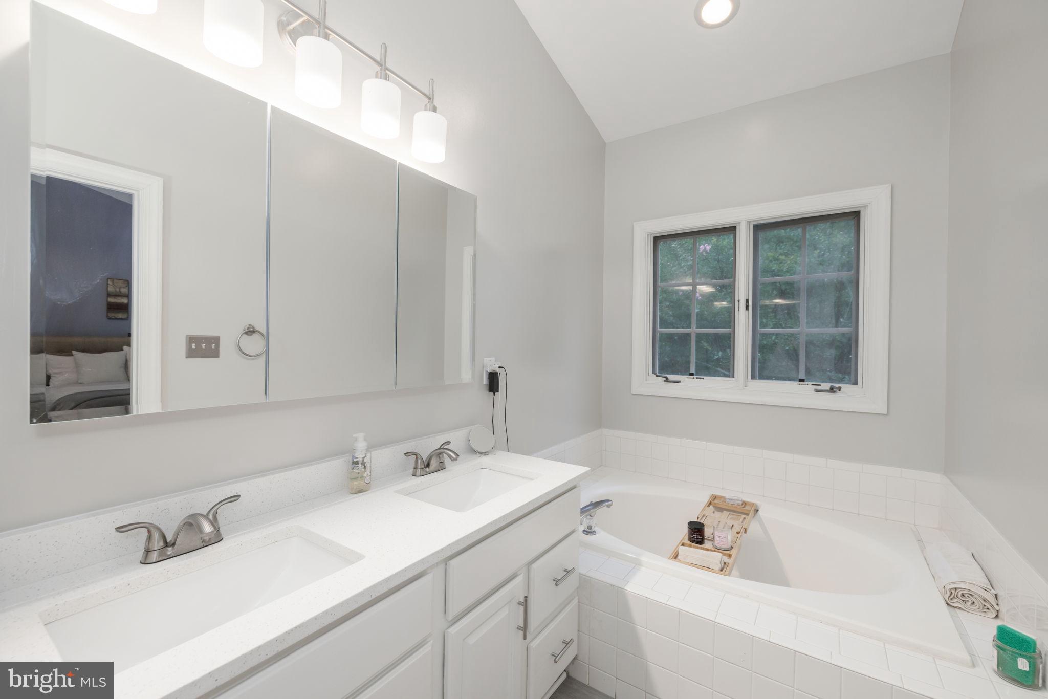6337 Simmer Circle Springfield, VA 22150 - Photo 38 of 50 a bathroom with a tub a sink and a window