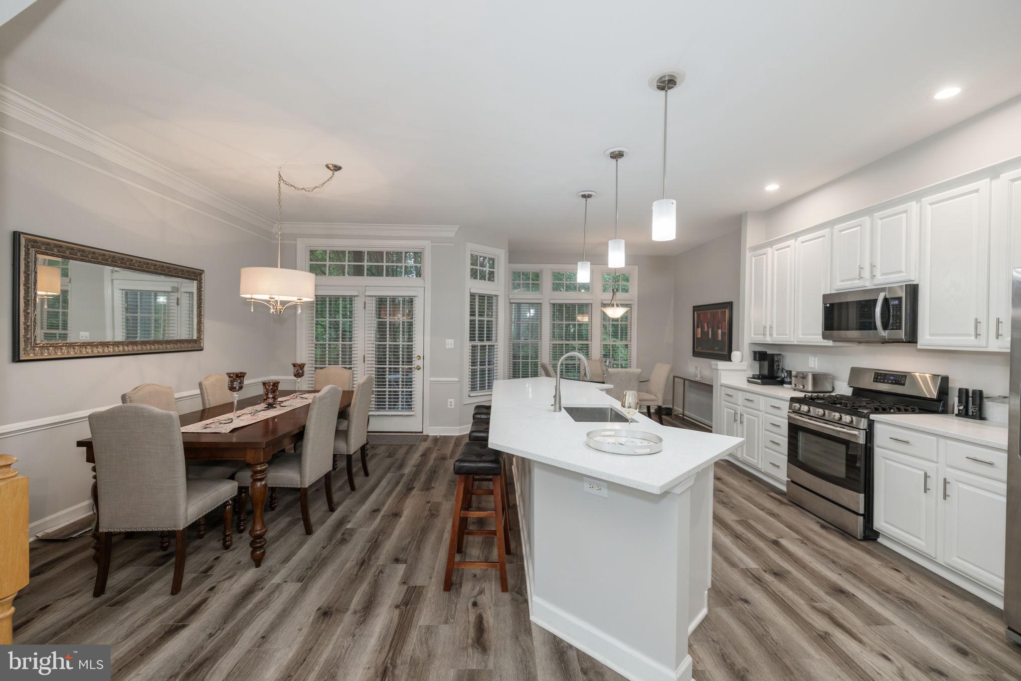 6337 Simmer Circle Springfield, VA 22150 - Photo 9 of 50 a large kitchen with a table chairs wooden floor and appliances