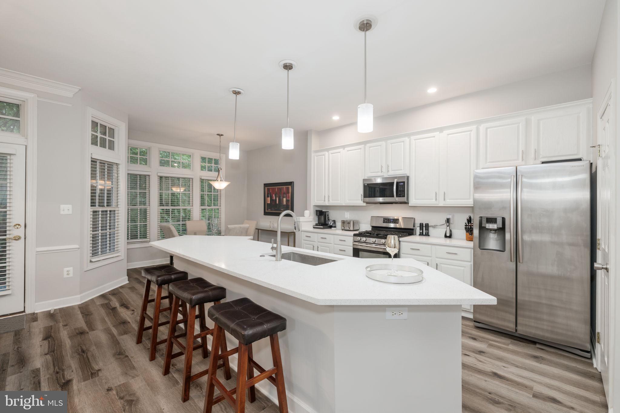 6337 Simmer Circle Springfield, VA 22150 - Photo 10 of 50 a kitchen with stainless steel appliances kitchen island granite countertop a sink a stove and a refrigerator