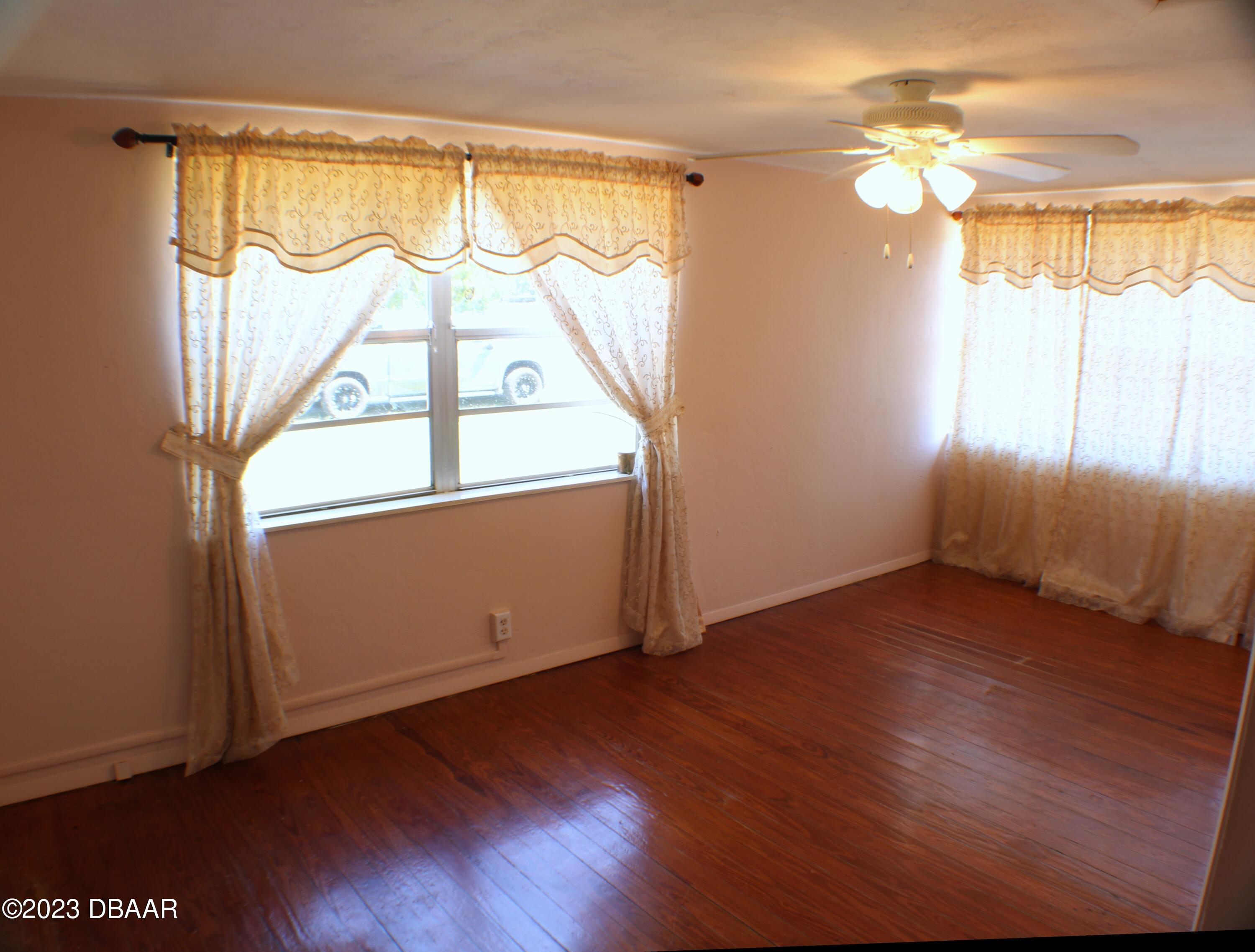 602 Flagler Avenue Edgewater, FL 32132 - Photo 11 of 15 an empty room with wooden floor and windows