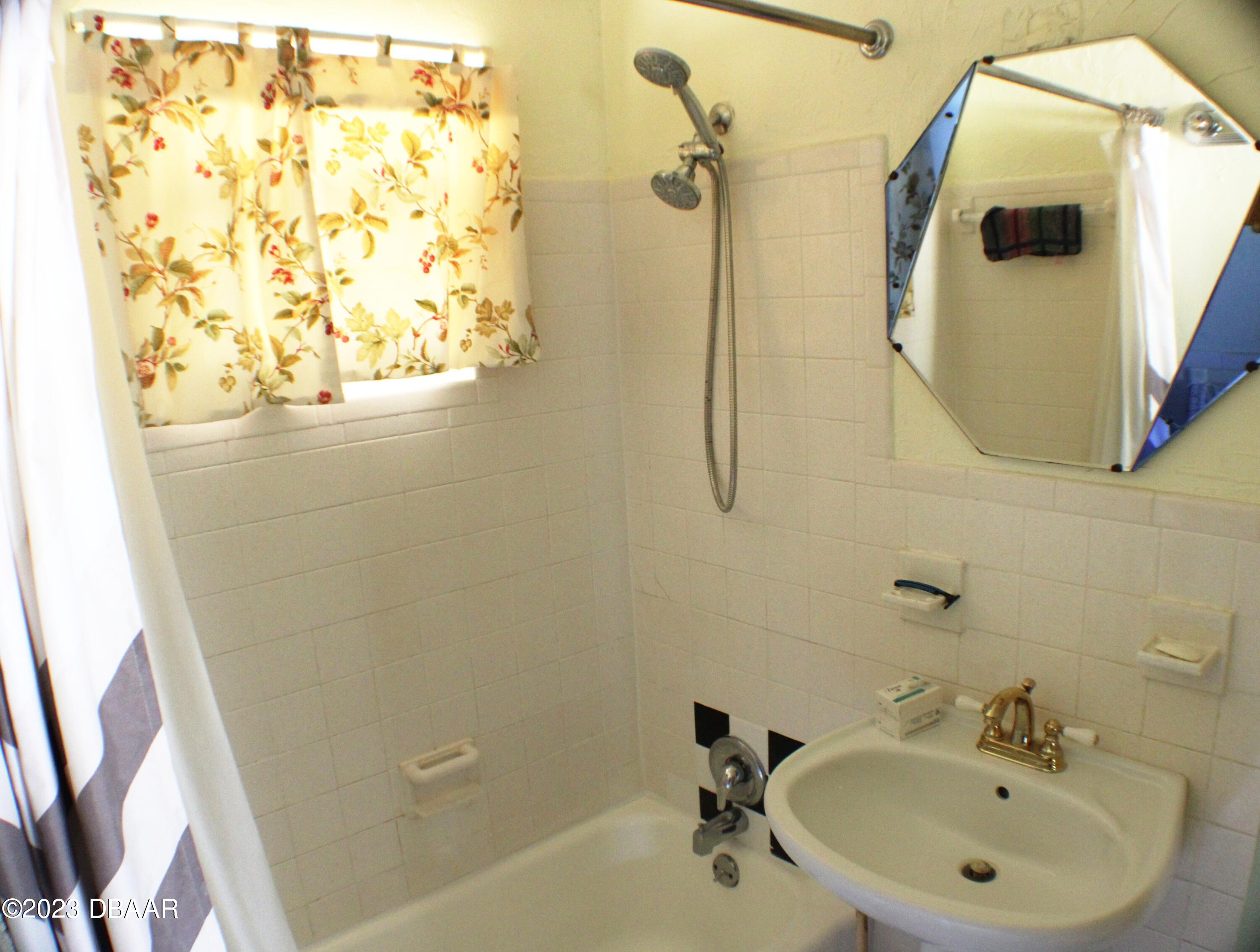 602 Flagler Avenue Edgewater, FL 32132 - Photo 13 of 15 a bathroom with a sink and mirror